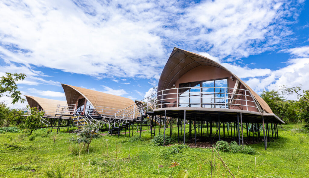 Exterior of luxury arched tented suites on raised wooden platforms at Ngorongoro Safari Lodge, Tanzania.